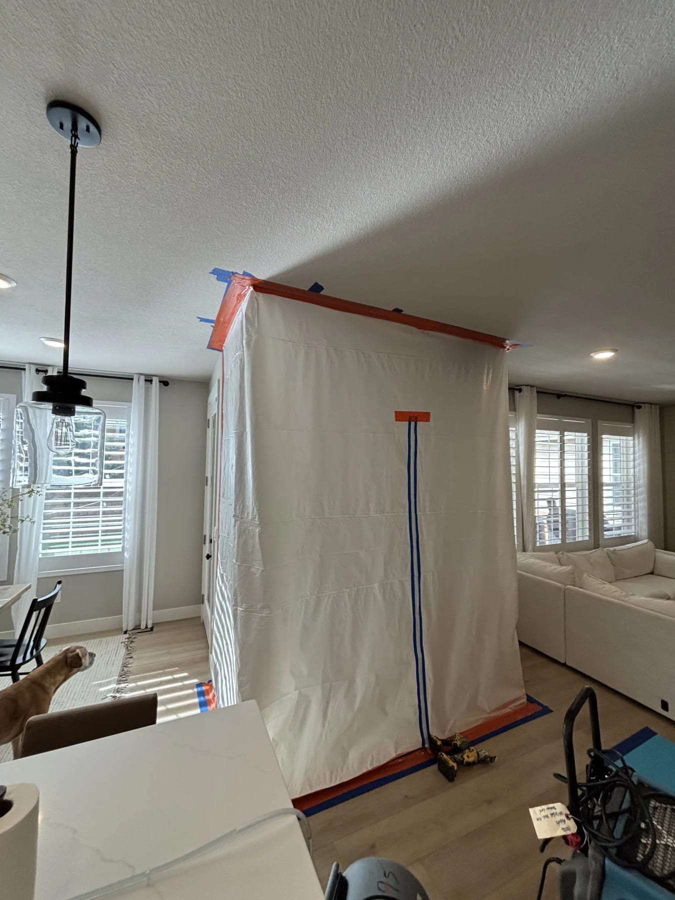 Plastic containment wall dividing a living room during work